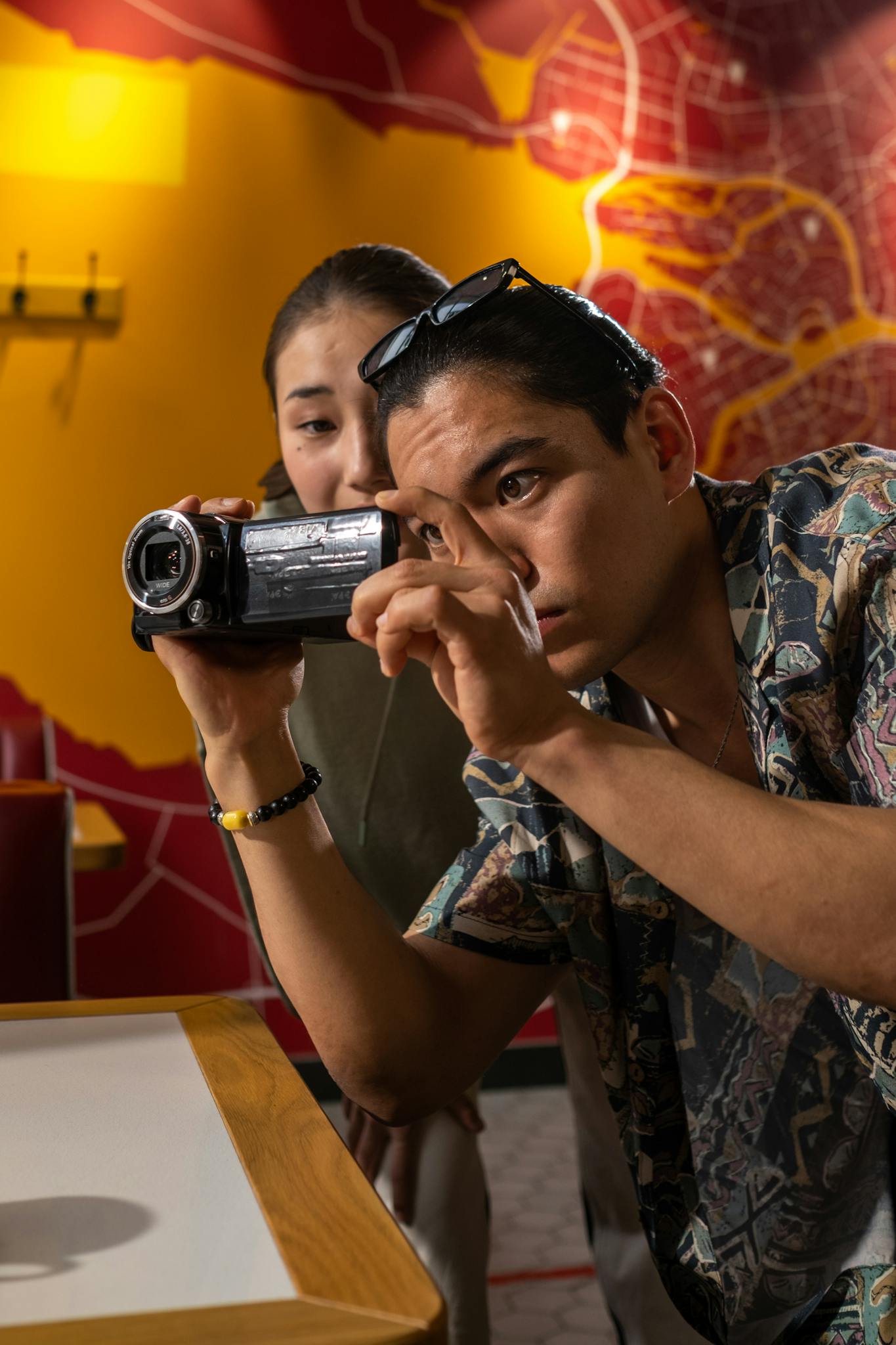 Two filmmakers capturing a scene indoors, focused on creativity and teamwork.